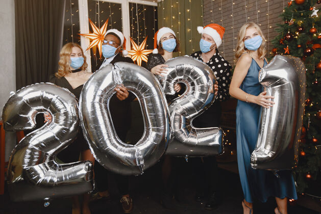 covid192021圣诞老人装饰中的人们冠状病毒概念新年集体庆祝活动2021年带气球的人们夜晚西装男人