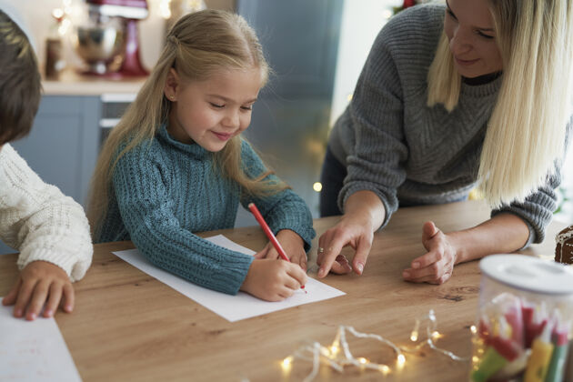 天真和妈妈一起给圣诞老人写信的女孩女孩蜡笔梦想