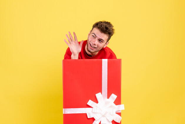 丝带正面图年轻男性站在礼品盒内包装雪年