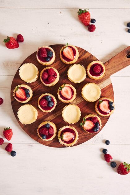美妙高角度拍摄的奶酪蛋糕与水果果冻和水果在一个木制的盘子木制奶油糕点