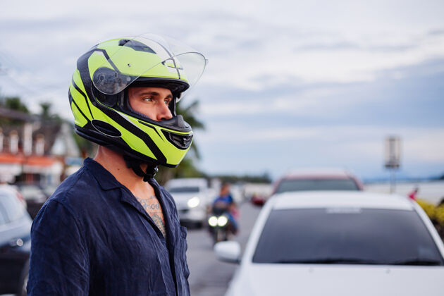 人日落时分 在泰国繁忙的公路边 一位戴着黄色头盔的男子的画像引擎骑速度