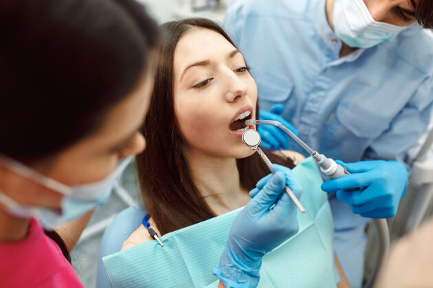 设备用镜子检查女人的牙齿牙齿医学诊所