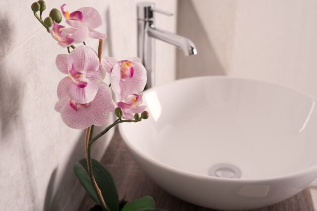 花卉柔和的焦点兰花旁边的水槽在浴室里兰花植物花卉