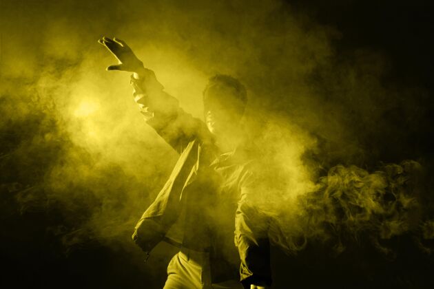 水平在烟雾中跳舞的人 带着亮光黑颜色黄
