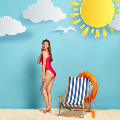 大海照片中的美女身材完美 身穿红色比基尼 在沙滩上晒太阳球拍休息晒黑