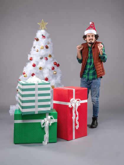 圣诞树圣诞礼物点亮的年轻男性帽子圣诞帽礼物