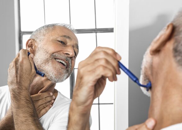 男性特写笑脸男人在镜子里刮胡子老年人灰海自理