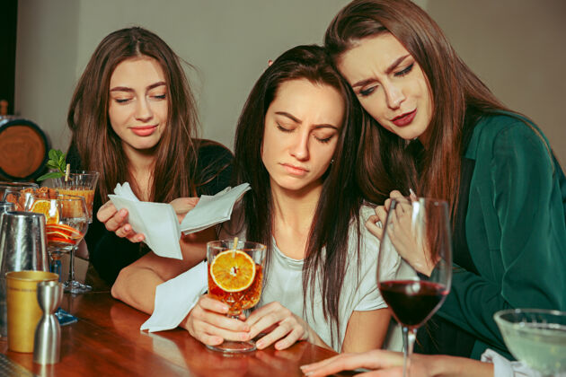 水果压力女性朋友在酒吧喝酒她们坐在一张木制桌子旁 喝着鸡尾酒干燥美丽在一起