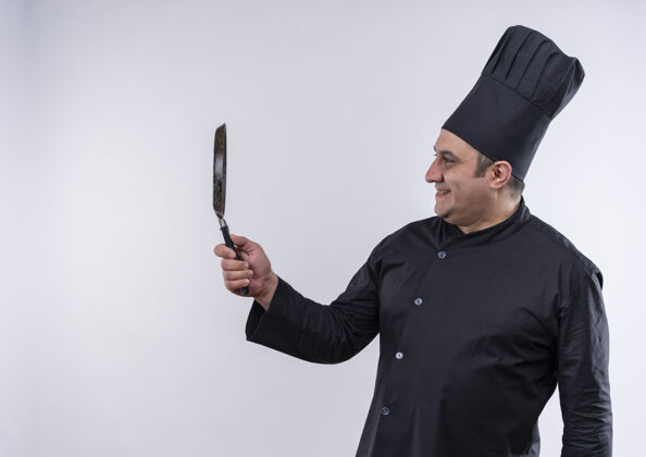 厨师微笑着的中年男厨师身着厨师制服 看着手中的煎锅与复印空间中年男制服