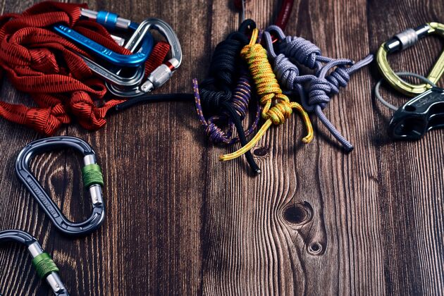 结特写镜头的许多彩色攀岩钩和结在木制表面登山保护绳索