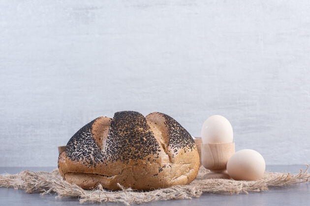 面包鸡蛋和芝麻面包放在大理石上黑芝麻面粉酵母