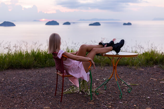 漂亮穿着夏装的年轻白种女人的浪漫写真 在山上的公园里享受着令人惊叹的热带海景绿色优雅紫色