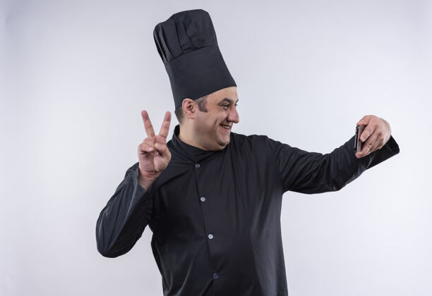 厨师微笑的中年男厨师身着厨师制服羚牛自拍展现和平姿态展示自拍厨师