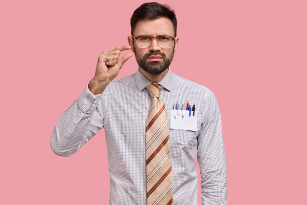 无胡子照片上是一个长着浓密胡须的无耻的年轻人 用手展示着一些小东西 展示着小额贷款 戴着一副大眼镜眼镜领带手势