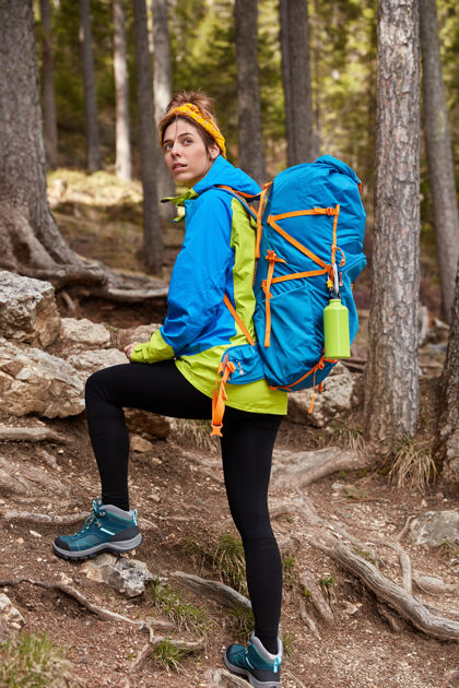 攀岩女游客在山林中行走 回首 克服长距离上山的垂直镜头徒步旅行运动帆布