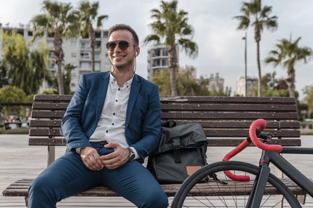 健康坐在长凳上戴墨镜的男人年轻骑自行车的成年人