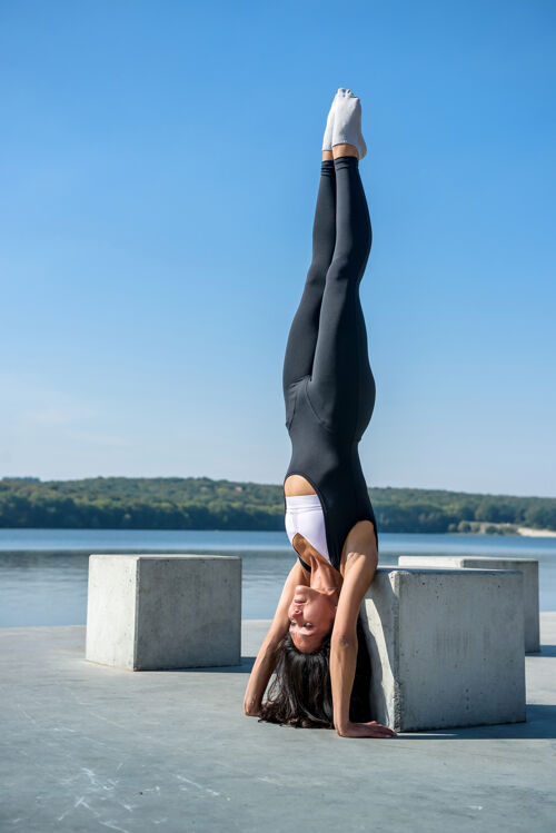 人运动型的年轻女子白天在湖边做健身操手臂训练女人