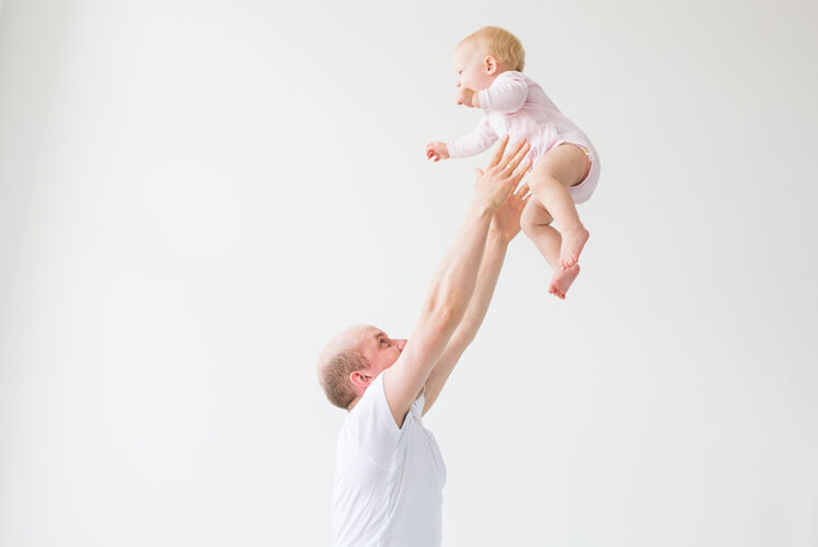 爸爸爸爸抱着女婴快乐的父亲抱起一个小孩 把他扔在地上回家快乐家庭宝贝