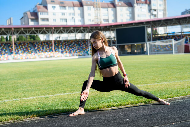 活跃年轻的运动型女子在体育场户外做早操健身身体健康