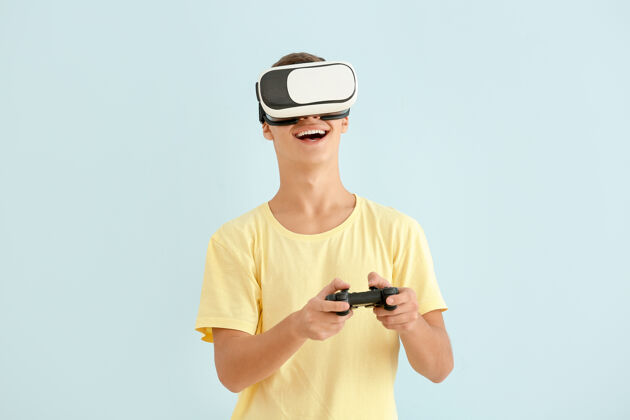 现实戴着虚拟现实眼镜玩电子游戏的少年男孩男孩虚拟现实耳机游戏