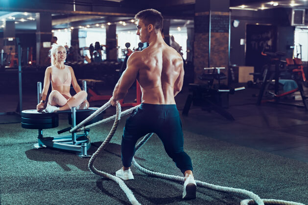 健康健身员在健身房用战绳锻炼努力健身房俱乐部