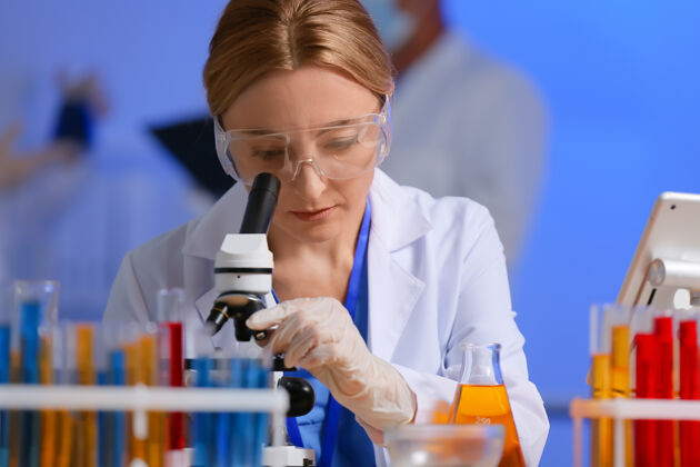 科学家女科学家在实验室里用显微镜工作年轻人工作颜色