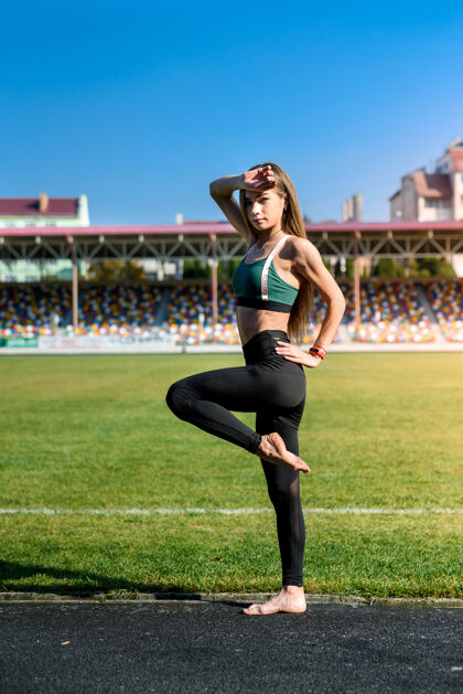 健康年轻的运动型女子在体育场户外做早操成人灵活能量