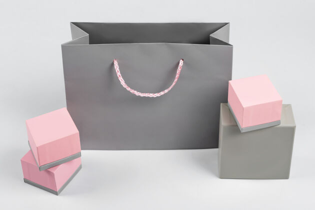 模型浅色背景上的灰色纸袋和粉色礼品盒文本可用空间购物 销售 惊喜或礼物概念灰色礼品纸张