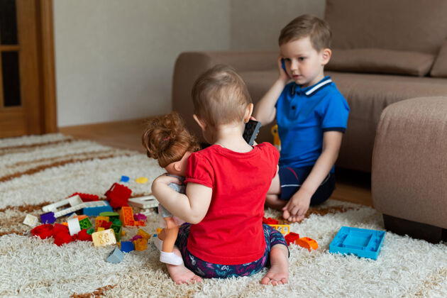 人兄妹俩玩着一个建筑工具 还玩着一个玩具电话婴儿幼儿园朋友