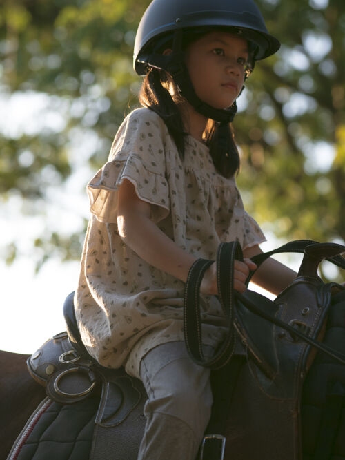 亚洲人亚洲学童女孩骑马 在牧场骑马或练习骑马动物骑乡村
