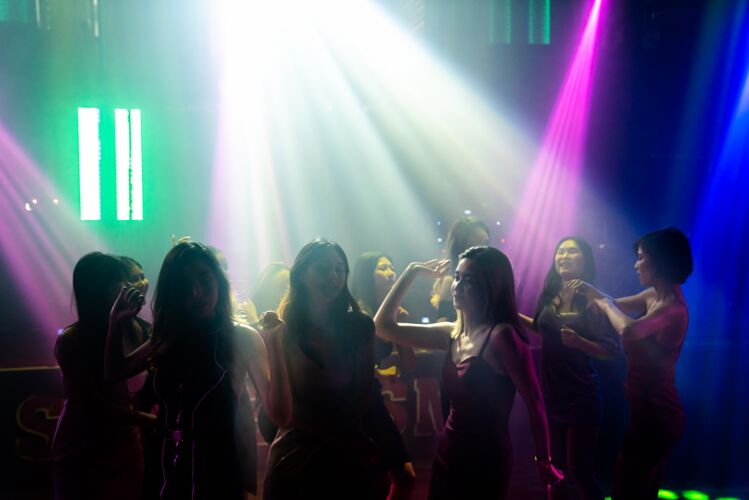 夜晚剪影形象的人跳舞迪斯科夜总会音乐从dj在舞台上女孩年轻乐趣