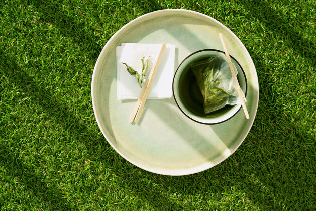 舒适柠檬马鞭草茶放在杯子里 用手工制作的茶包放在绿草上舒适的概念闭合自然光输液柑橘头顶