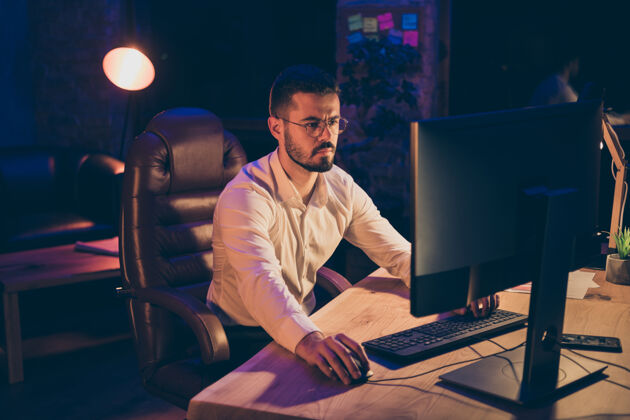 项目专注的人像坐在电脑桌上工作男人夜晚加班