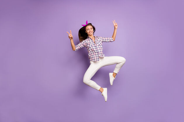 梦幻全身照片内容青春女孩享受跳跃做v型标志跳跃格子蹦床