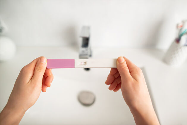 显示年轻女子在浴室里检查怀孕测试包妇女怀孕排卵
