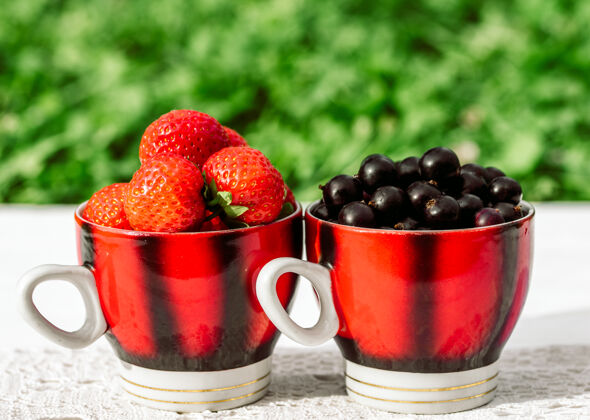 有机草莓和黑醋栗在一个杯子里 概念夏天在村里食物甜点五颜六色
