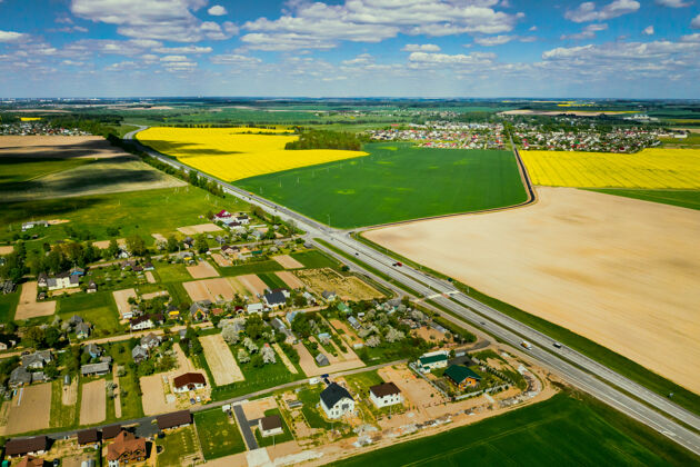 土地黄色油菜田和村庄的顶视图中国的一块油菜籽播种地白俄罗斯村子里是一片油菜地农业花开花