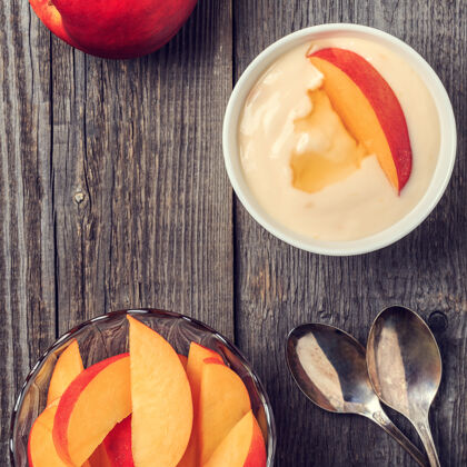 勺子自制酸奶和新鲜的桃子放在木头上提神新鲜零食