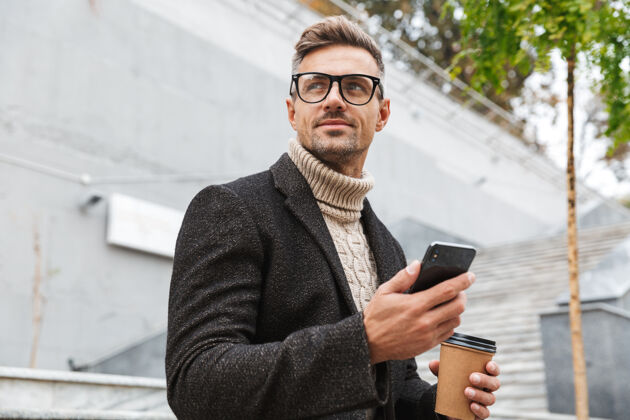 电话帅哥穿着夹克拿着手机 坐在户外喝外卖咖啡软件咖啡户外