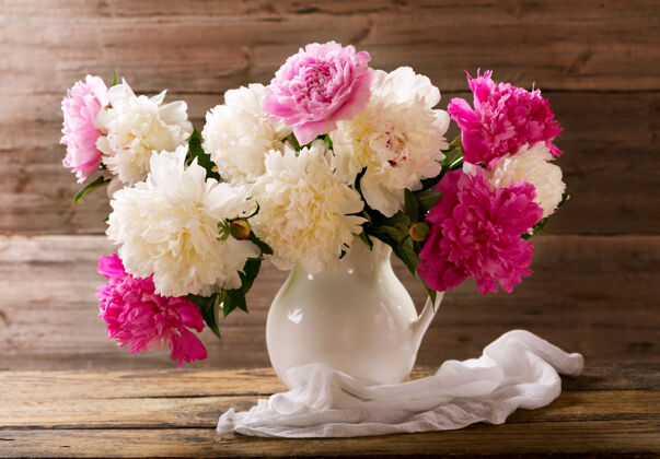 自然一束五颜六色的牡丹花放在木桌上的白色罐子里植物开花牡丹