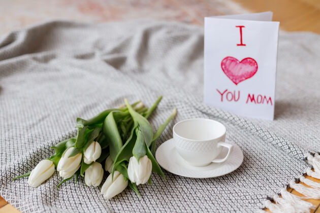 花朵明信片杯茶和郁金香在毯子上花卉装饰卡片