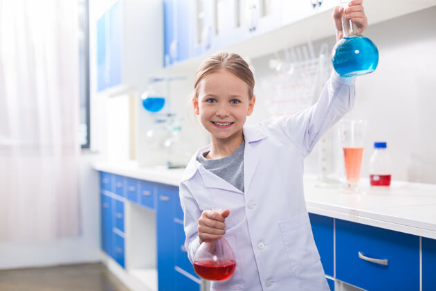实验室最喜欢的科学在化学实验室里 快乐的女孩微笑着拿着烧瓶教育生物年轻