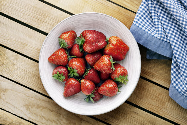 碗美味多汁的草莓放在木制背景的盘子里吃草莓维生素
