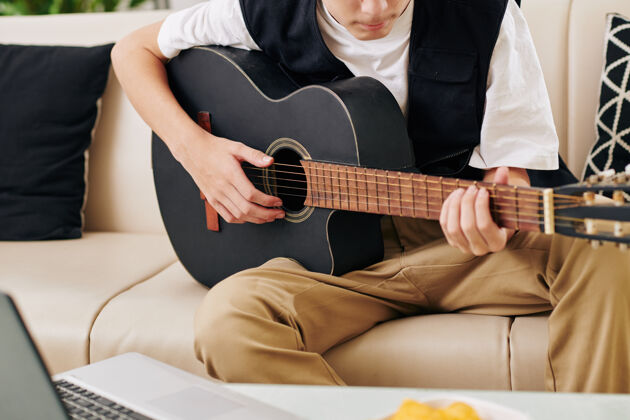 乐器弦一个严肃的青少年男孩在笔记本电脑前玩吉他的剪贴图片在他的博客上播放在线3d眼镜青少年