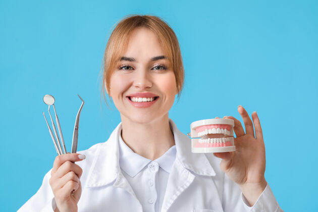 牙医女牙医用塑料下巴模型和工具在彩色表面人预防工作