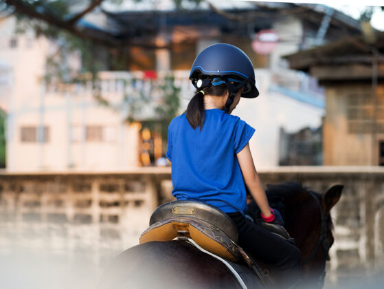 田野亚洲学童女孩骑马 在牧场骑马或练习骑马爱人户外