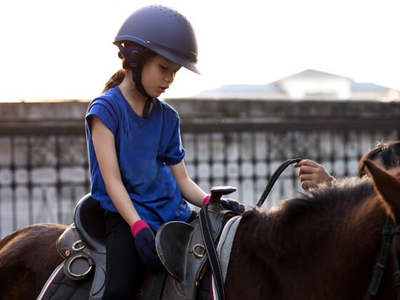 亚洲人亚洲学童女孩骑马 在牧场骑马或练习骑马种马户外可爱