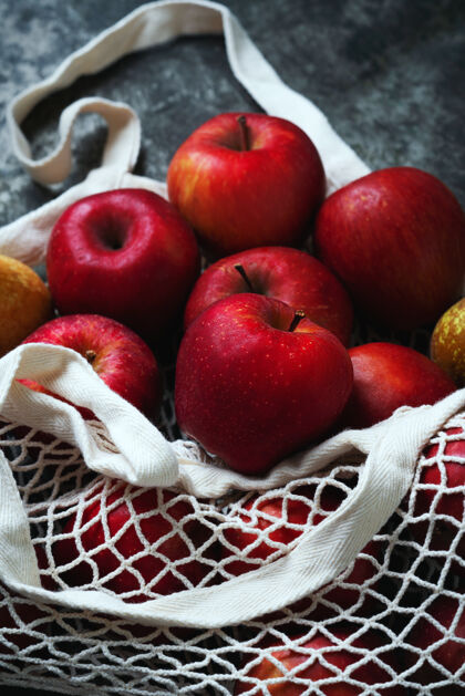 废物苹果在桌子上方的网袋里发芽可持续性和有意识的消费观念顶视图平躺头顶食品多汁
