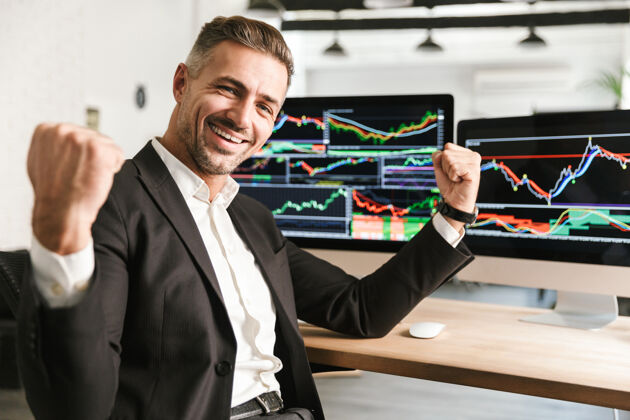 公司30多岁的快乐商人穿着西装在电脑上工作 屏幕上有图形和图表成功经理白种人