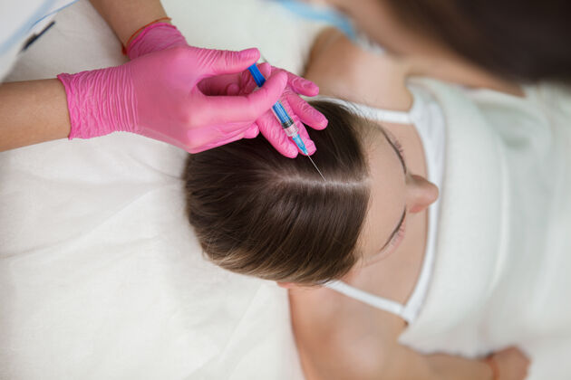 专业一个女人正在接受美容师的脱发治疗注射垂直镜头女人注射器治疗
